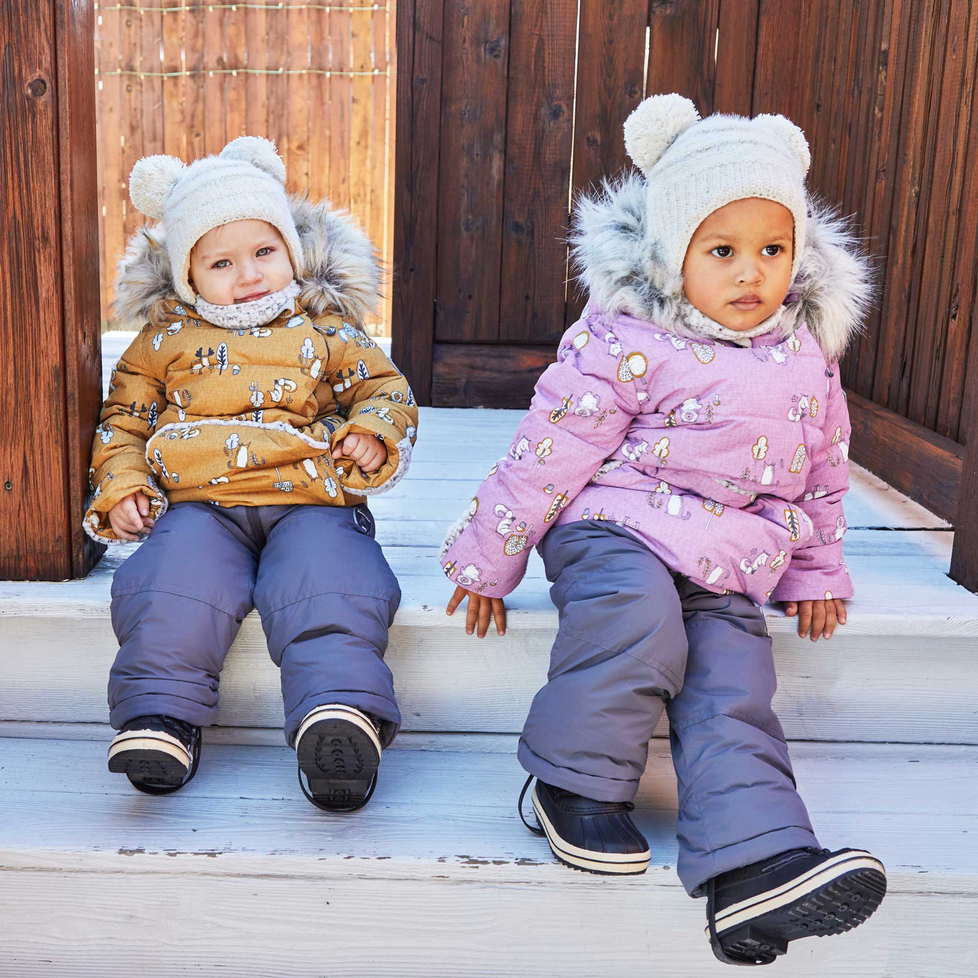 A vibrant yellow two-piece baby snowsuit featuring woodland animal prints, with solid pants and a printed jacket, designed for warmth and style.