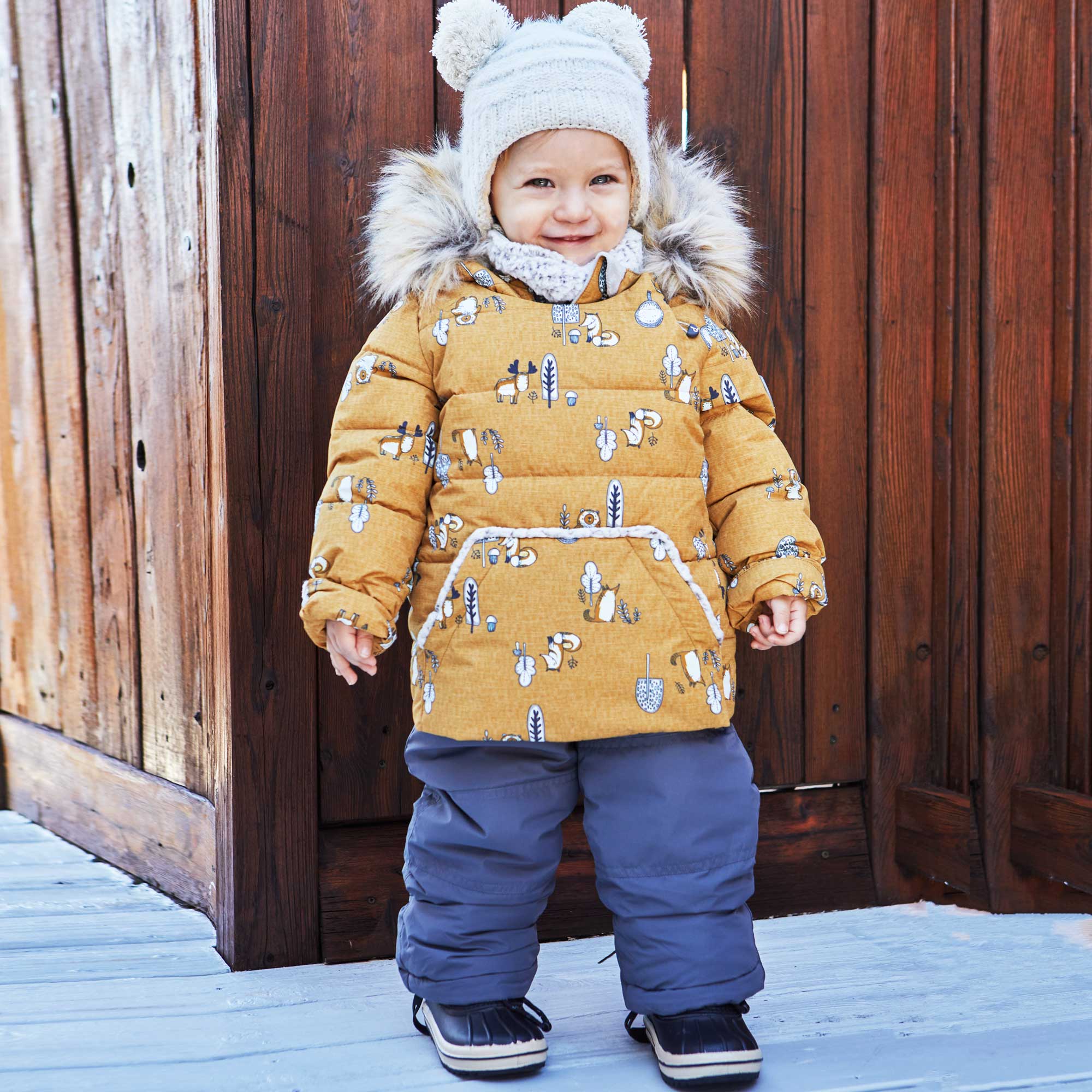 A vibrant yellow two-piece baby snowsuit featuring woodland animal prints, with solid pants and a printed jacket, designed for warmth and style.