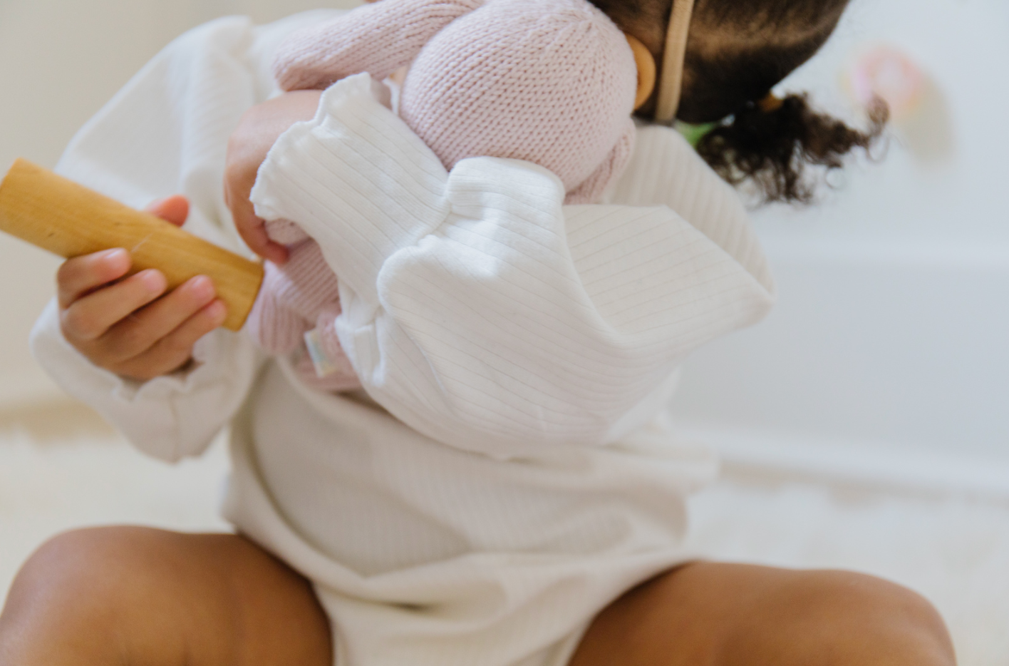 A soft ribbed baby bodysuit in green, ecru, and beige colors, showcasing its gentle fabric and stylish design.