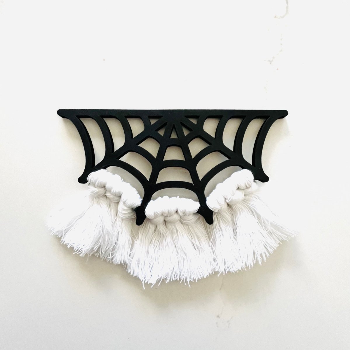A beautifully crafted Spiderweb Macrame Garland featuring intricate laser-cut spiderweb designs strung on a strong cotton cord, perfect for Halloween decor.
