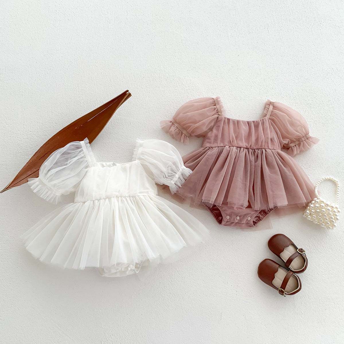 A cute Spring and Summer Baby Girls Short Sleeves Solid Color Mesh Dress in white and pink, perfect for warm weather.