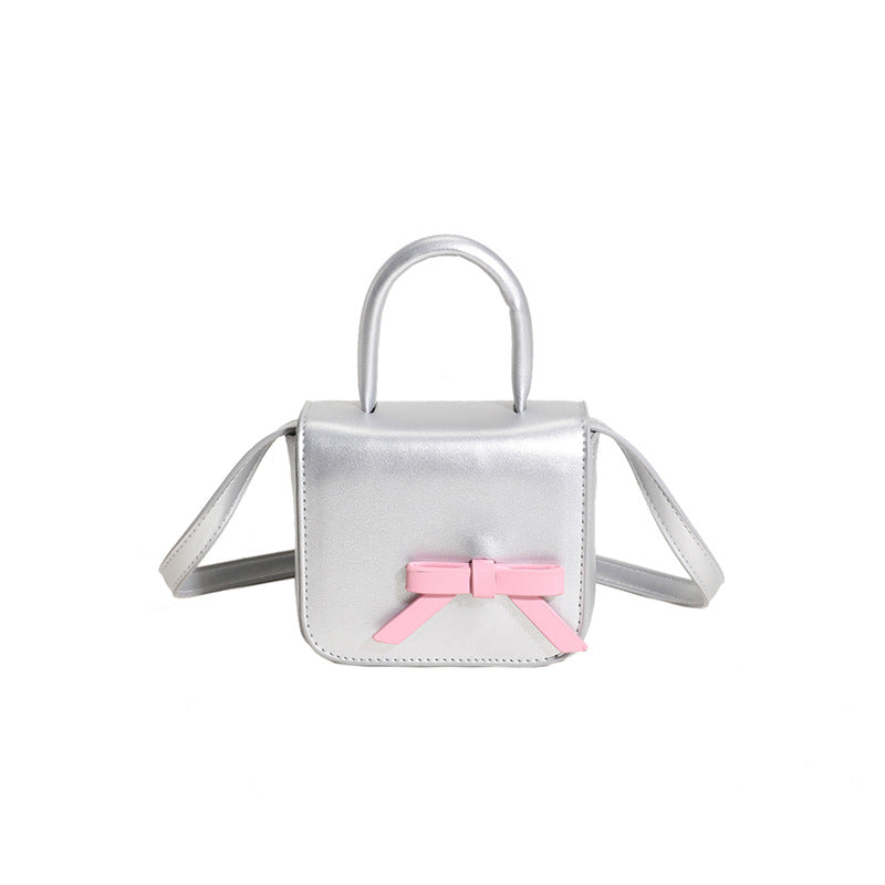 Stylish Creative Carry-On Girls’ Portable Mini Bow Princess Crossbody bag in white, black, pink, and silver colors with a cute bow design.