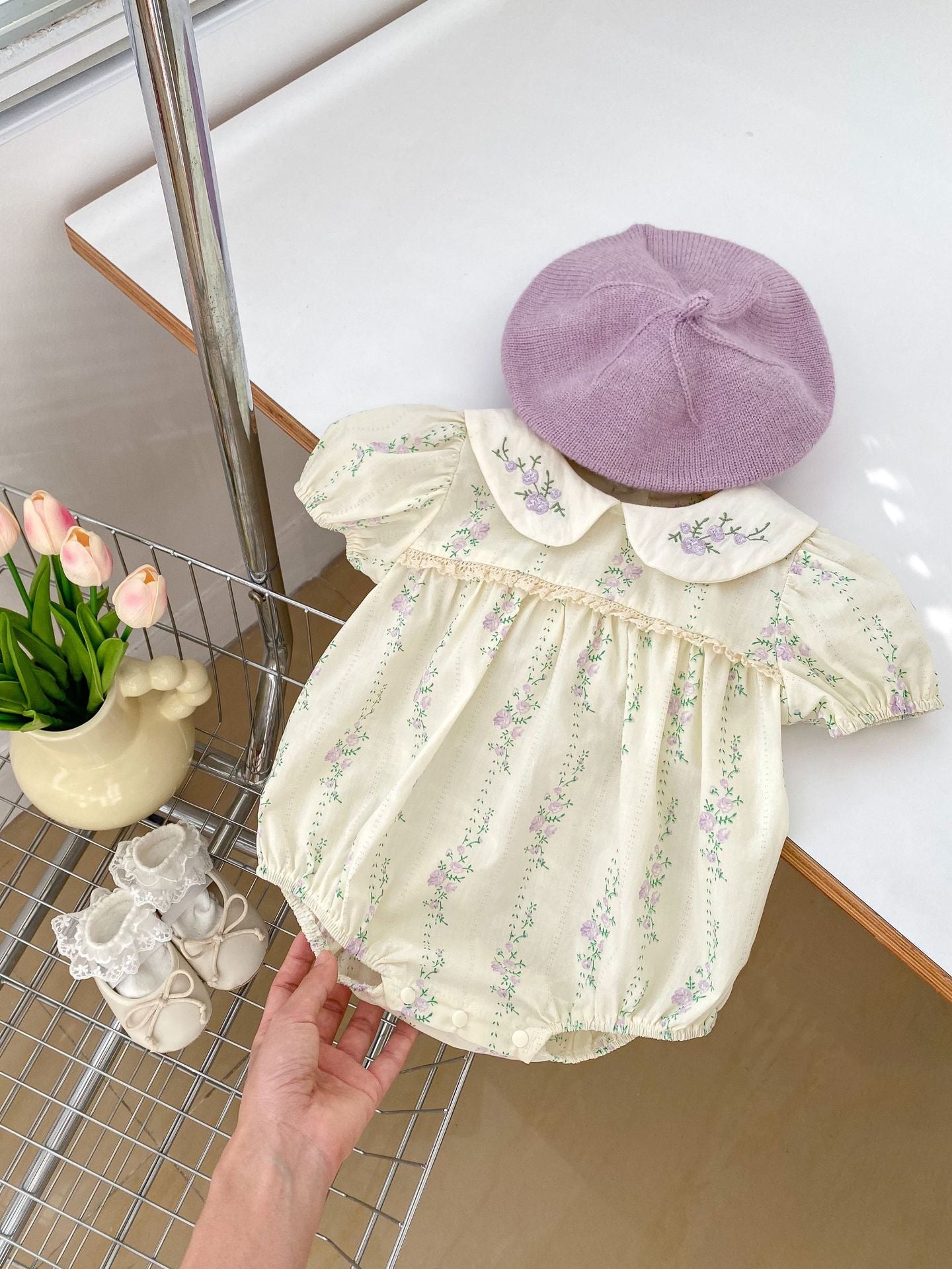 Summer baby girls onesie featuring a floral and vine pattern in beige cotton, perfect for warm weather.