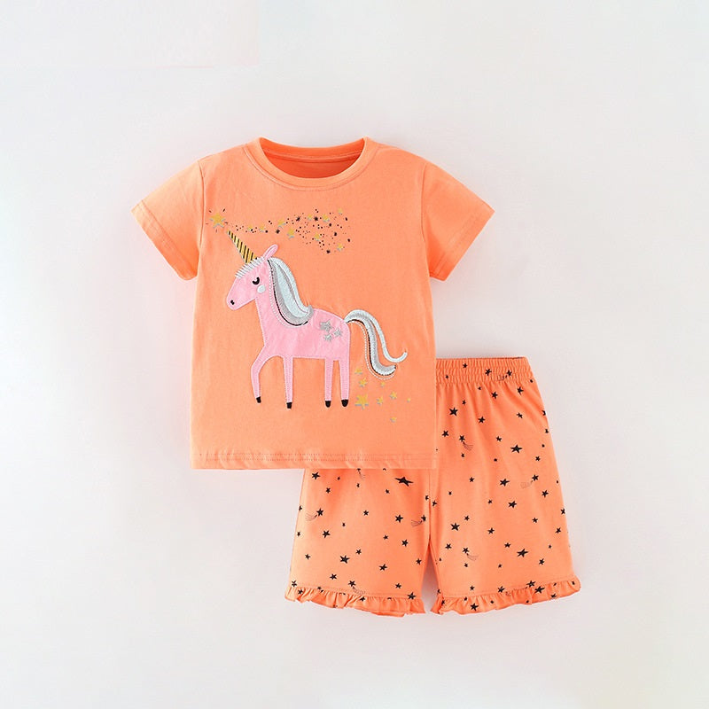 Summer outfit for baby girls featuring a unicorn and stars pattern in bright orange color, consisting of a T-shirt and shorts.