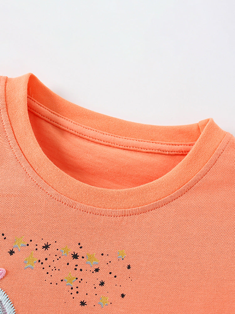 Summer outfit for baby girls featuring a unicorn and stars pattern in bright orange color, consisting of a T-shirt and shorts.