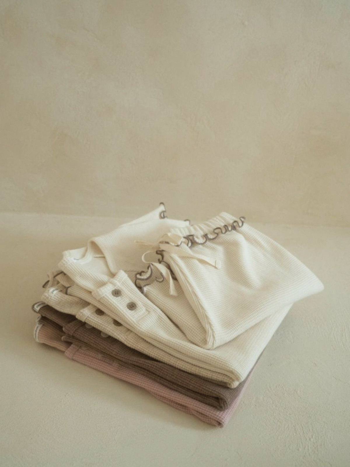 A collection of Summer Baby Kids Unisex Solid Color Waffle Grid Short Sleeves in Pink, Khaki, Beige, and Coffee colors, showcasing their casual style.