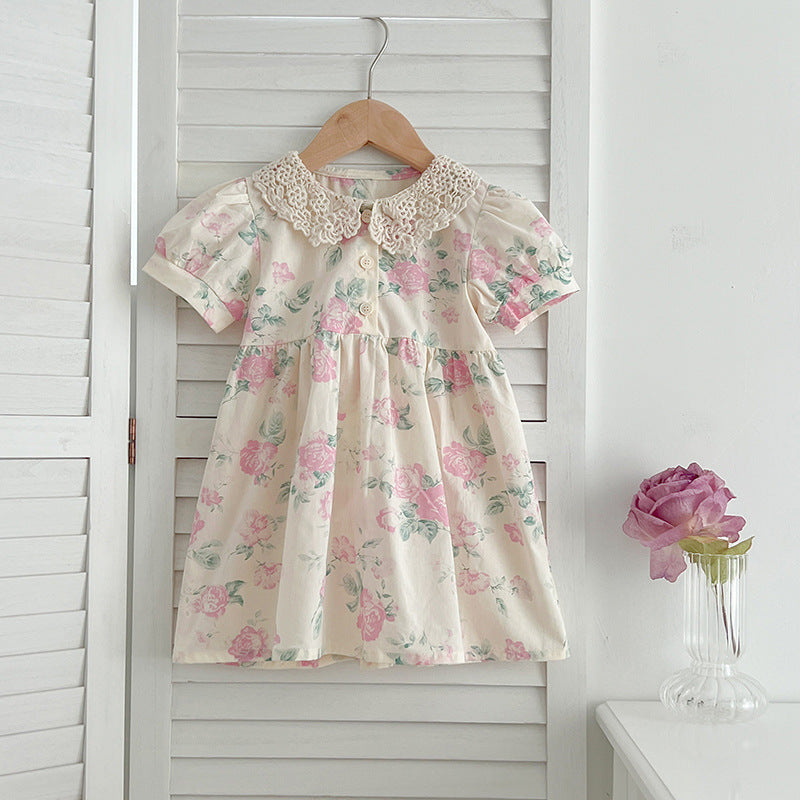 A cute summer dress for girls featuring a floral pattern and a hollow out Peter Pan collar, available in pink and beige.