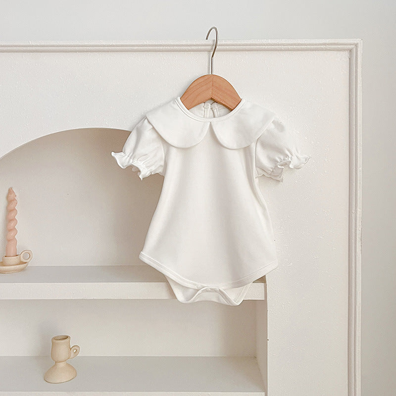 White baby romper on hanger.