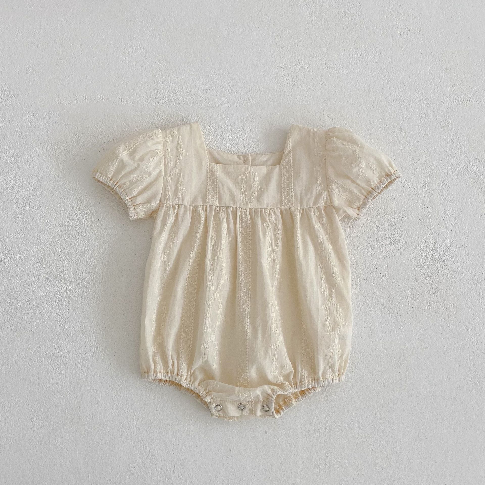 Summer girls onesies in beige and apricot with square neck and embroidery details, perfect for warm weather.