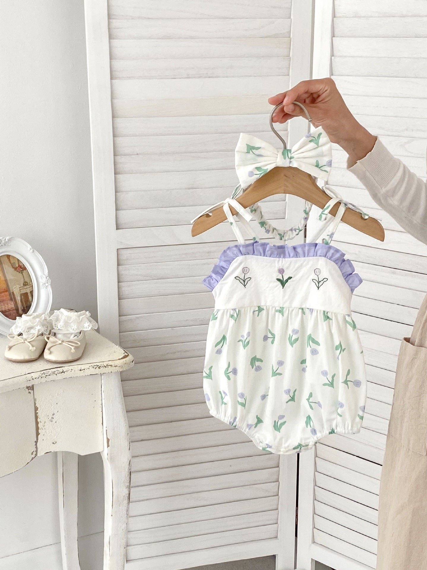 A cute purple floral pattern sleeveless strap onesie for baby girls, perfect for summer wear.