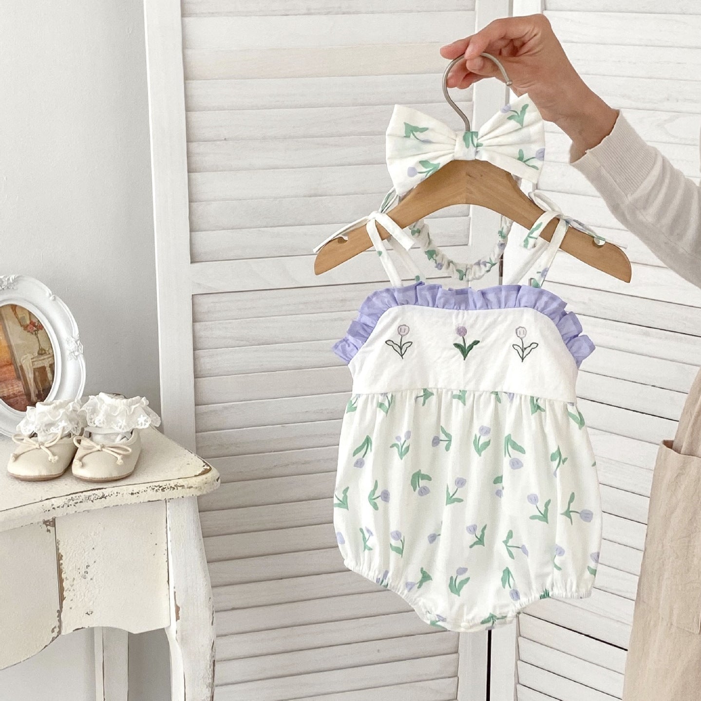 A cute purple floral pattern sleeveless strap onesie for baby girls, perfect for summer wear.