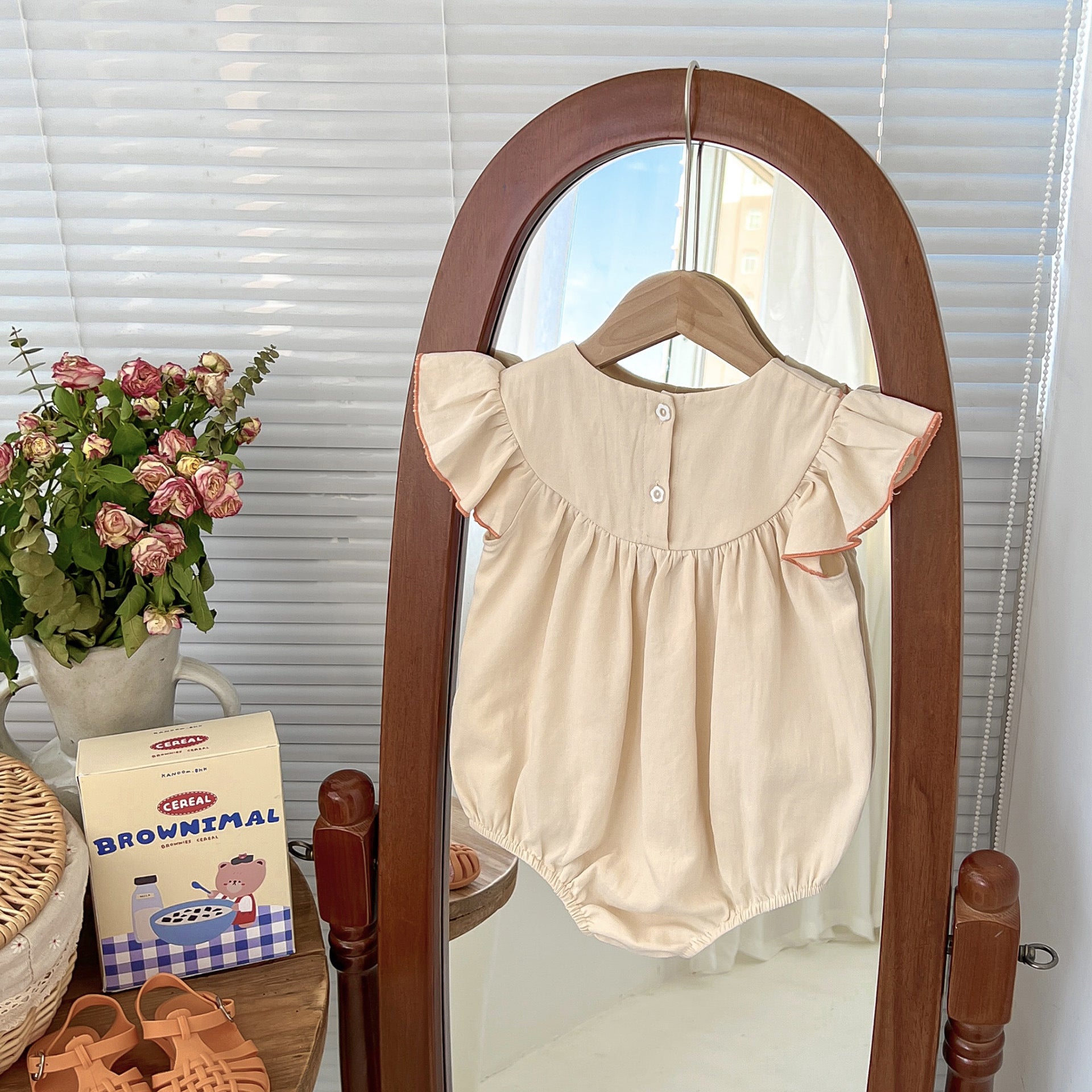 A cute apricot teddy for baby girls featuring fly sleeves and a cartoon pattern, perfect for summer wear.