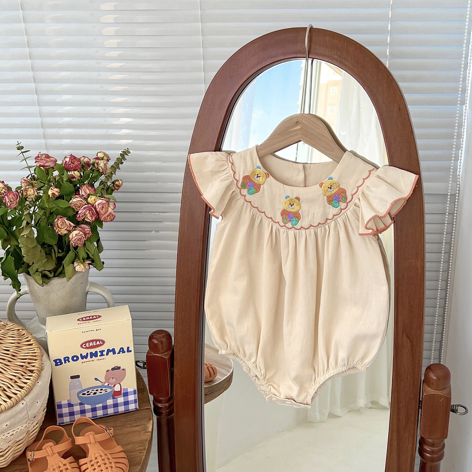 A cute apricot teddy for baby girls featuring fly sleeves and a cartoon pattern, perfect for summer wear.