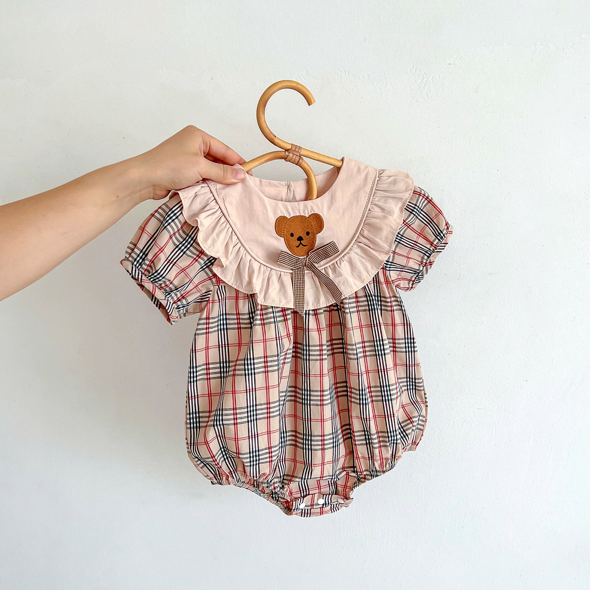 Khaki plaid teddy for baby girls with short sleeves and crew neck, made from soft cotton material.