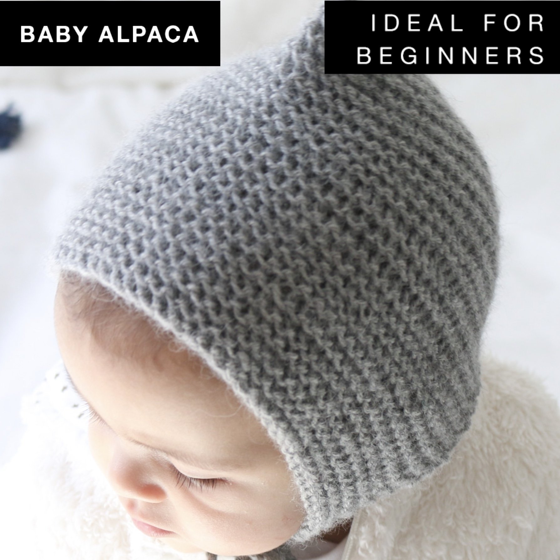 Titi Hood Knitting Kit featuring grey baby alpaca yarn, wooden knitting needles, and accessories for beginners.