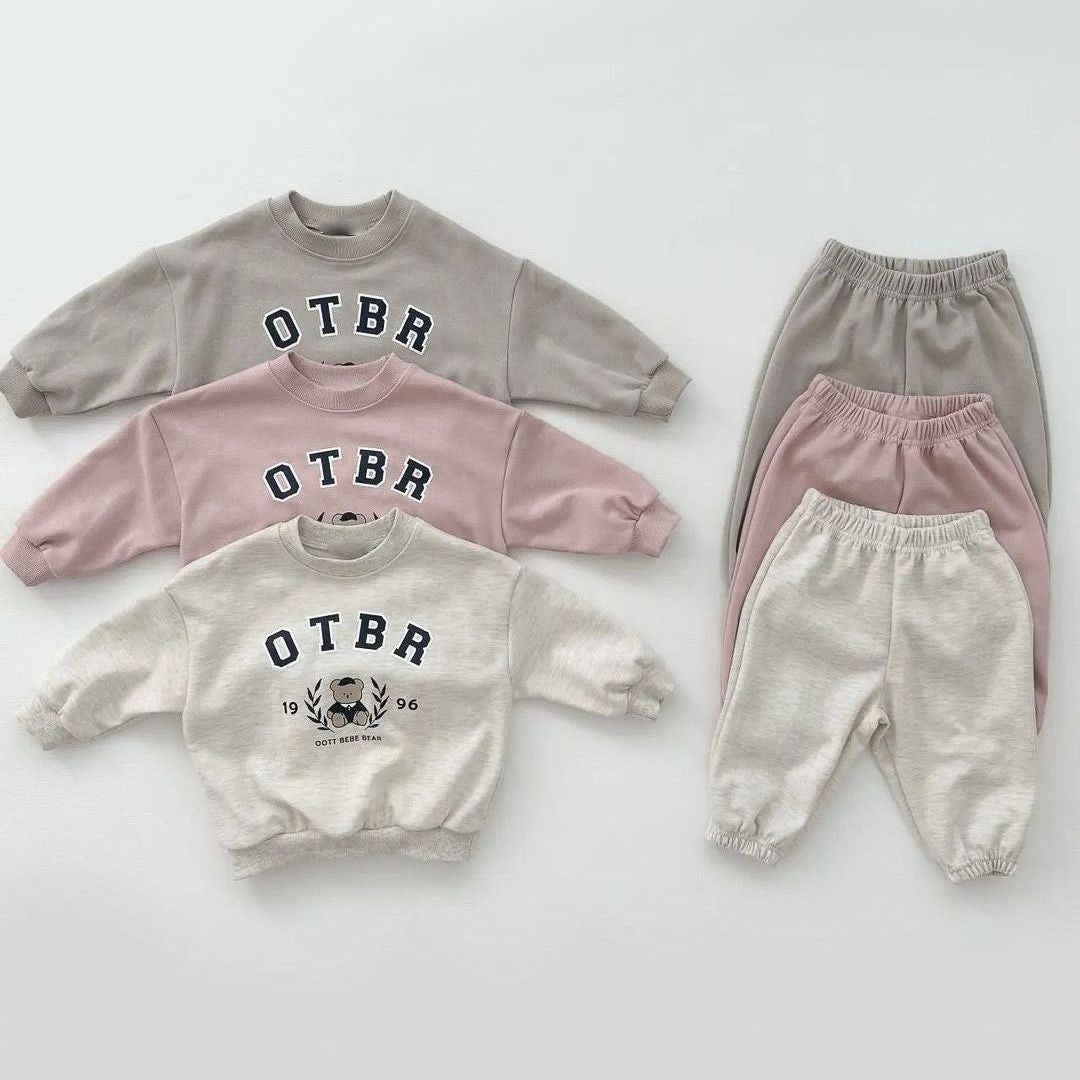 Unisex Baby Letter Print Combo featuring a cartoon pattern top and long pants in pink, grey, and apricot colors, perfect for baby girls.