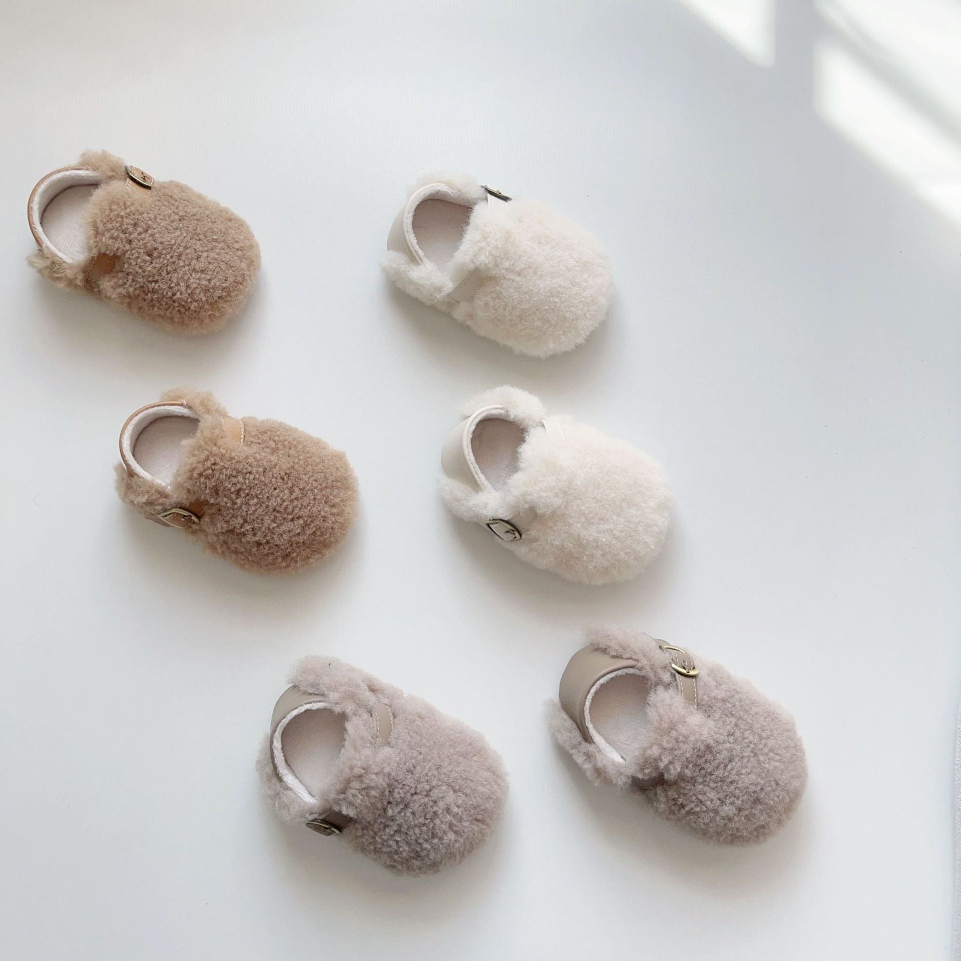 Cozy fleece toddler shoes in white, grey, and apricot colors, designed for comfort and warmth during winter.