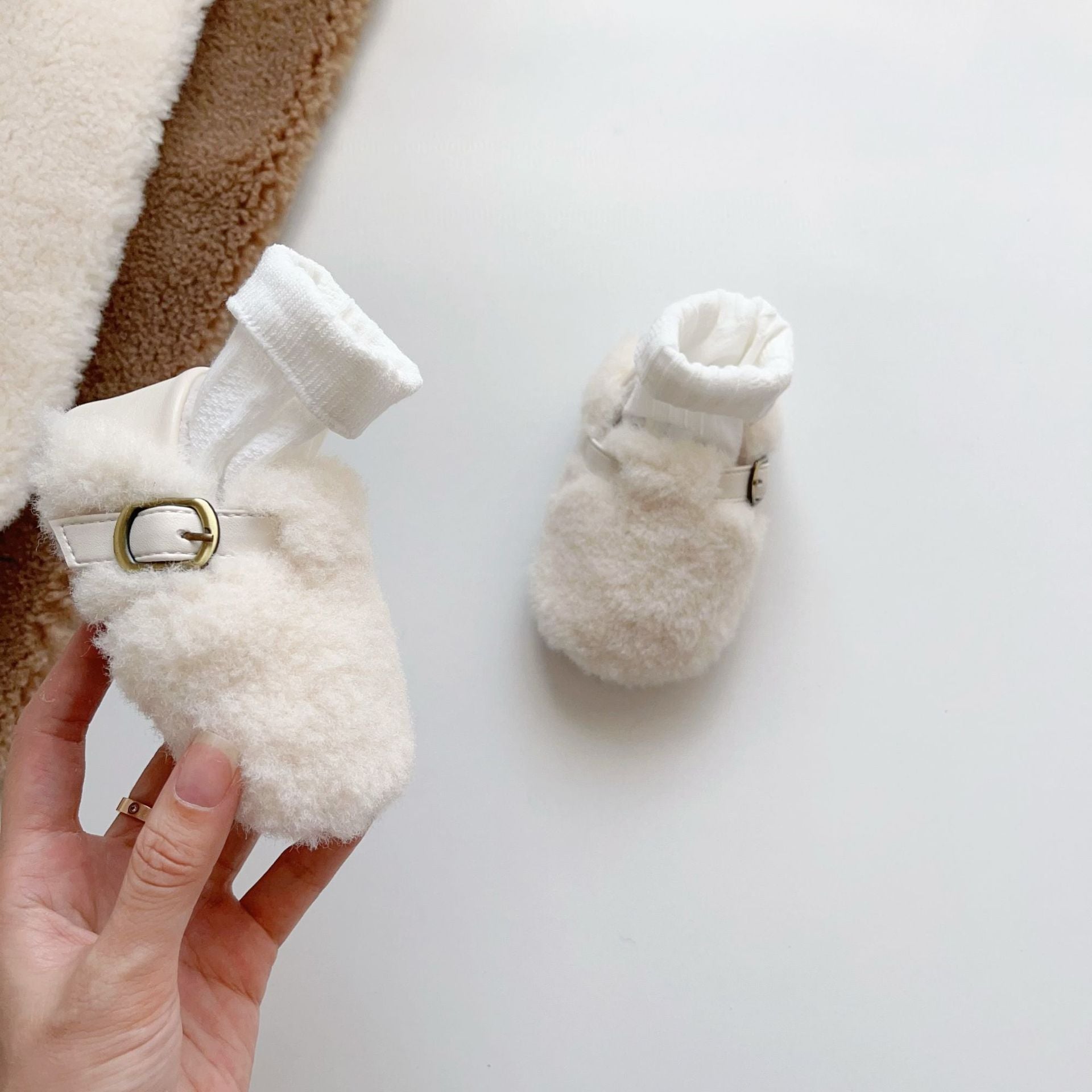 Cozy fleece toddler shoes in white, grey, and apricot colors, designed for comfort and warmth during winter.