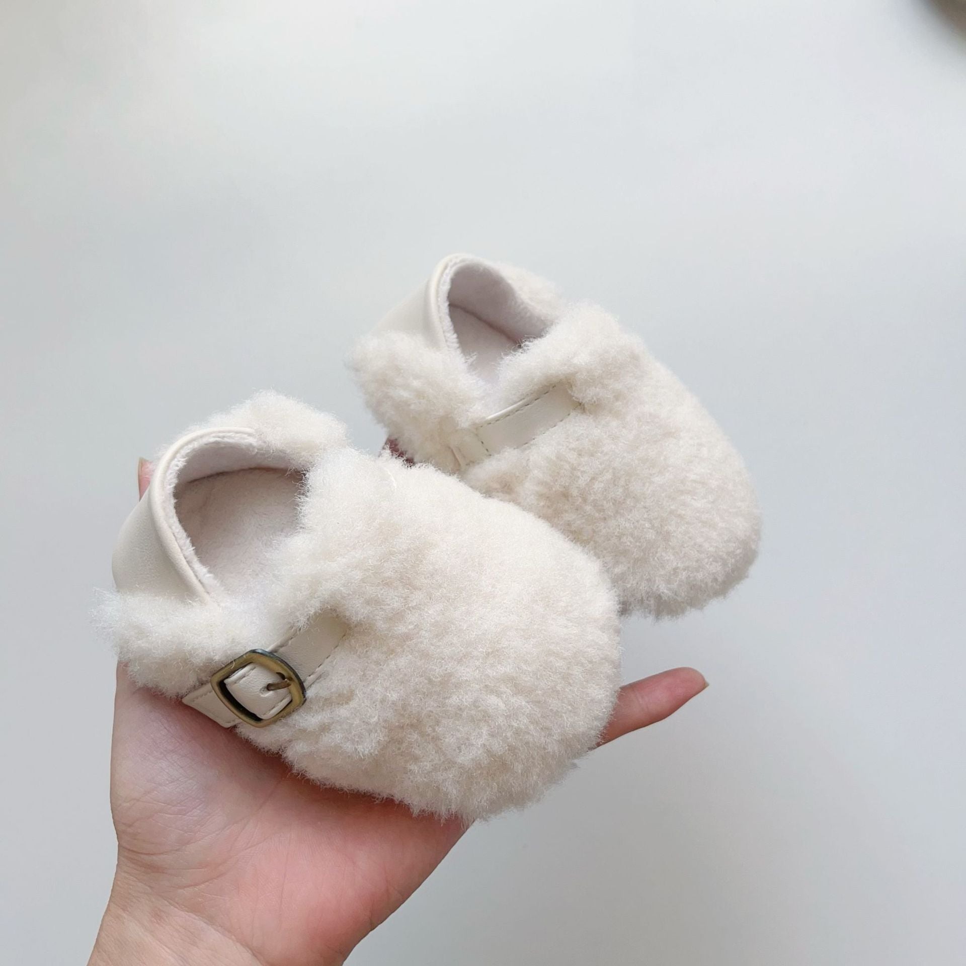 Cozy fleece toddler shoes in white, grey, and apricot colors, designed for comfort and warmth during winter.