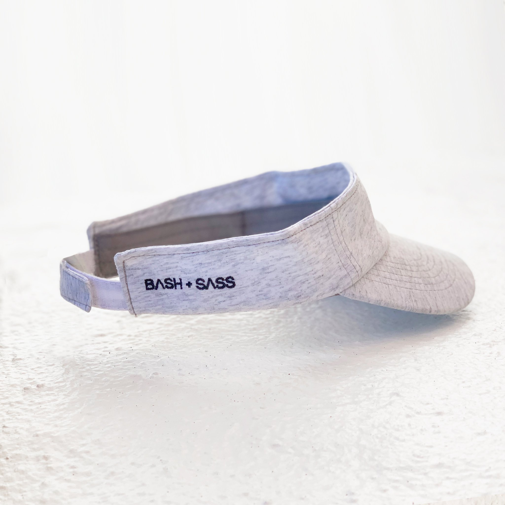 X + O Sun Visor featuring embroidered monsters and adjustable strap, perfect for sunny days.