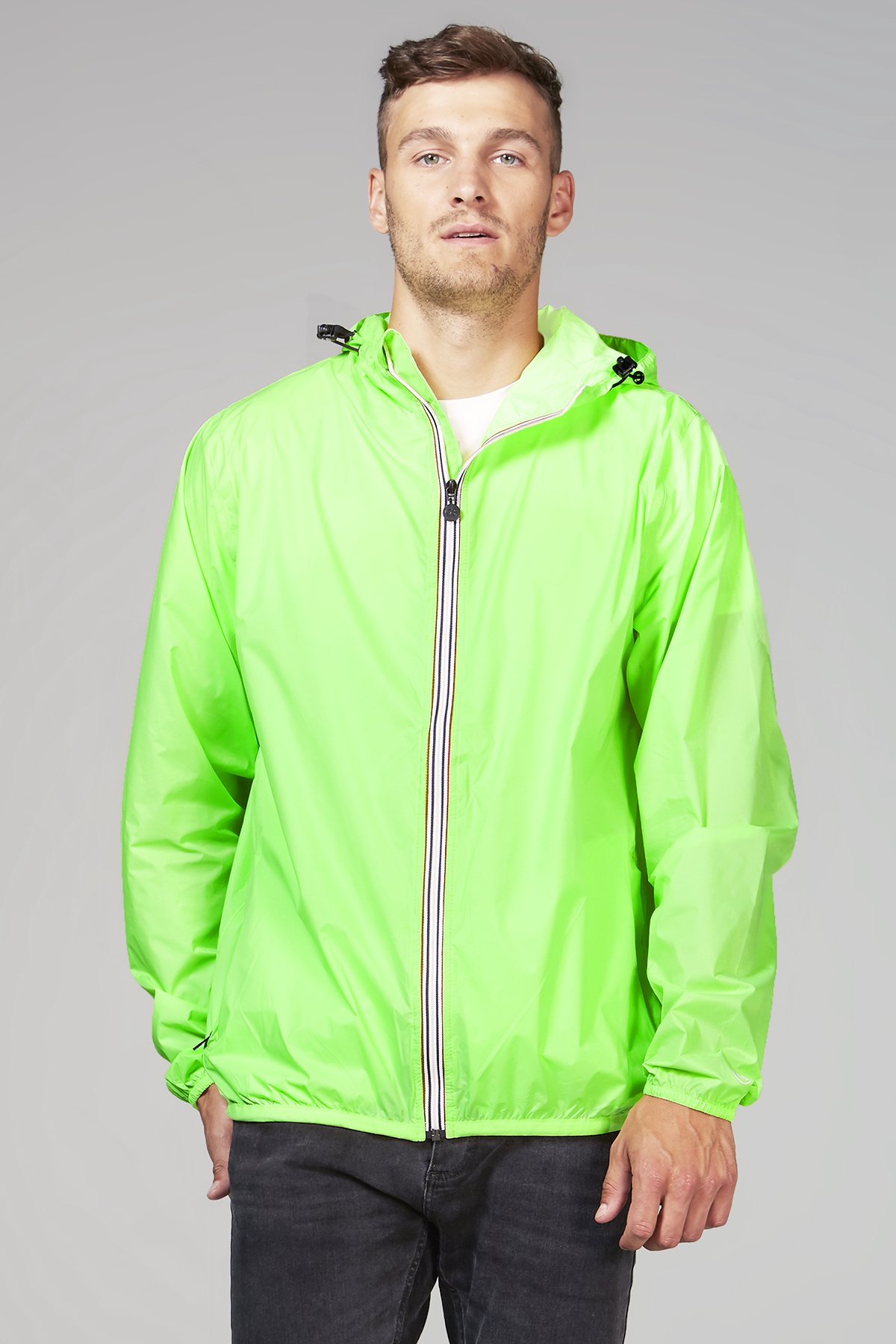 A vibrant green fluo full zip packable rain jacket, showcasing its waterproof fabric and compact design, ideal for outdoor activities.