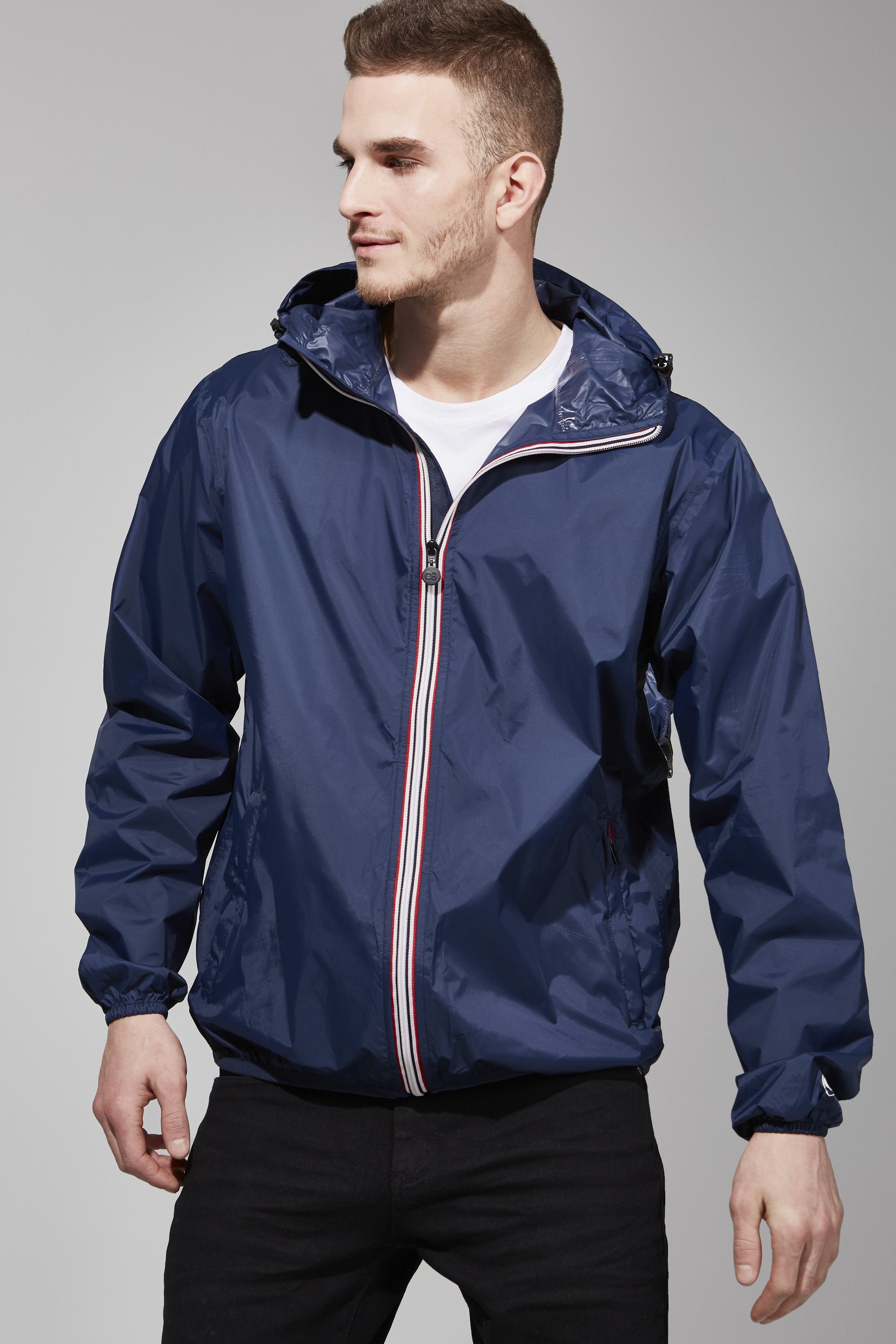 Navy full zip packable rain jacket displayed on a hanger, showcasing its waterproof fabric and compact design.