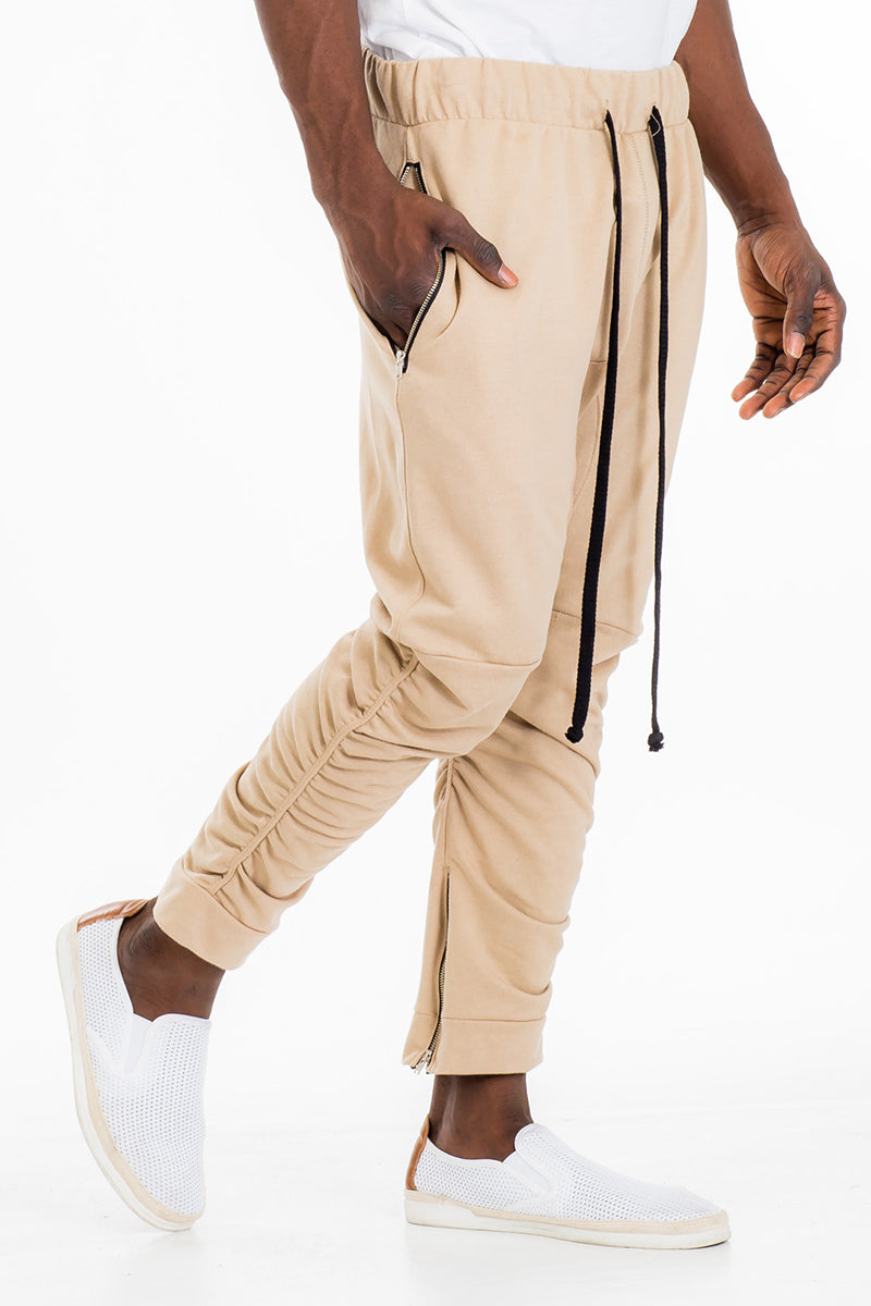 Gathered Cotton Sweats featuring an elastic waistband, zippered bottom hemline, and scrunched ankle design, displayed on a model.