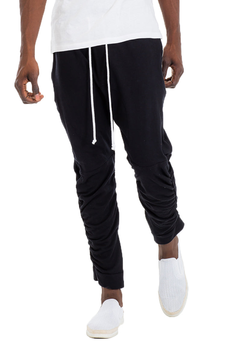 Gathered Cotton Sweats featuring an elastic waistband, zippered bottom hemline, and scrunched ankle design, displayed on a model.