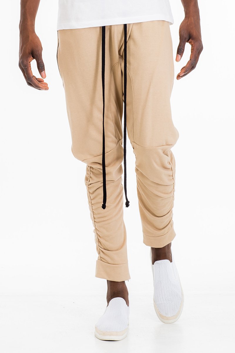 Gathered Cotton Sweats featuring an elastic waistband, zippered bottom hemline, and scrunched ankle design, displayed on a model.