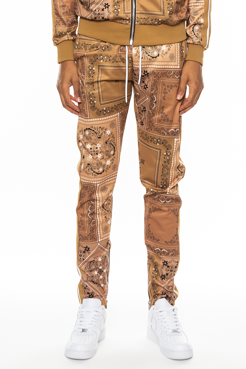 A pair of stylish paisley all over print pants featuring an elastic waist, drawstring, standard pockets, and ankle zippers.