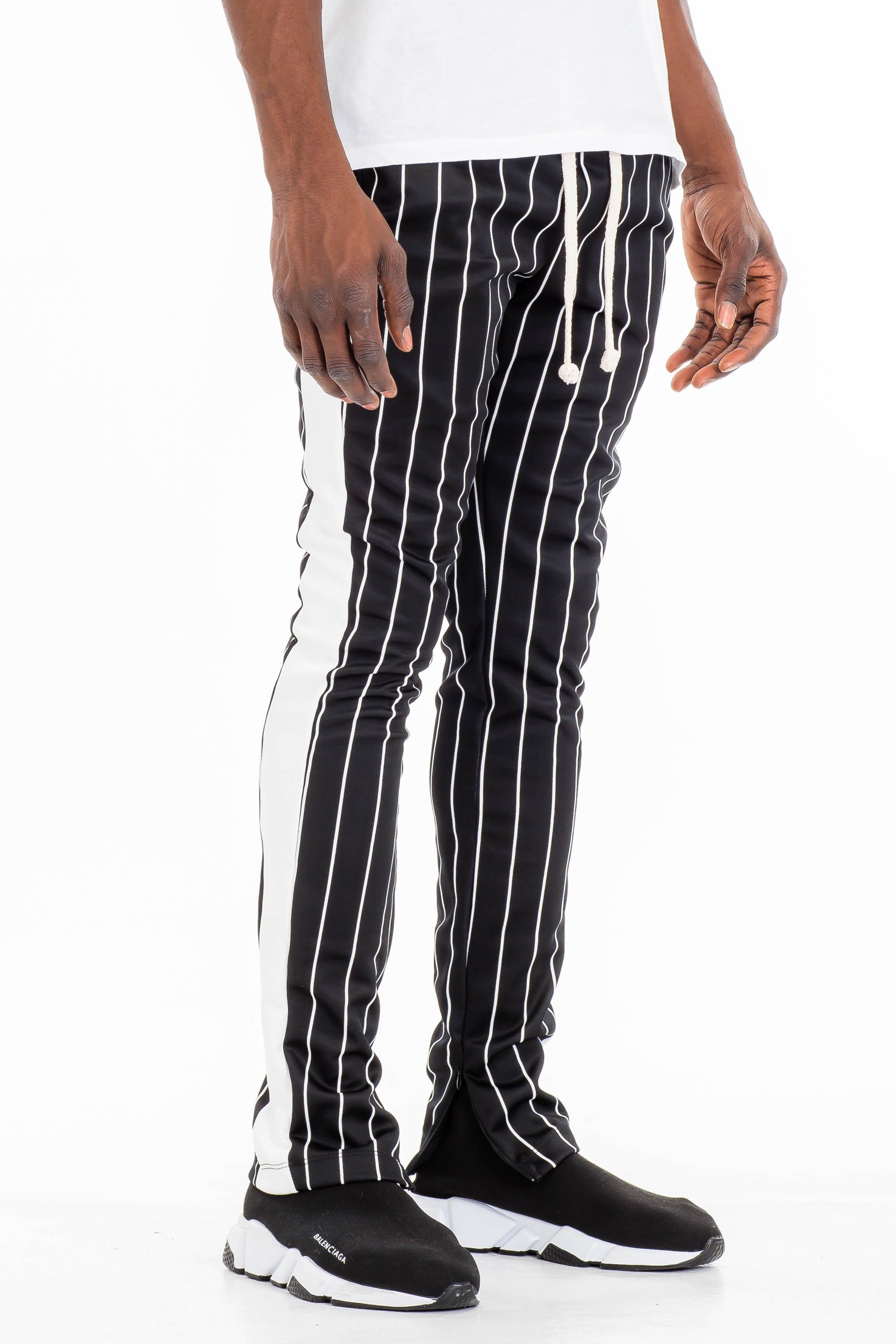 A pair of stylish pin stripe track pants featuring a skinny fit, elastic waistband with drawstring, and standard pockets, displayed on a neutral background.