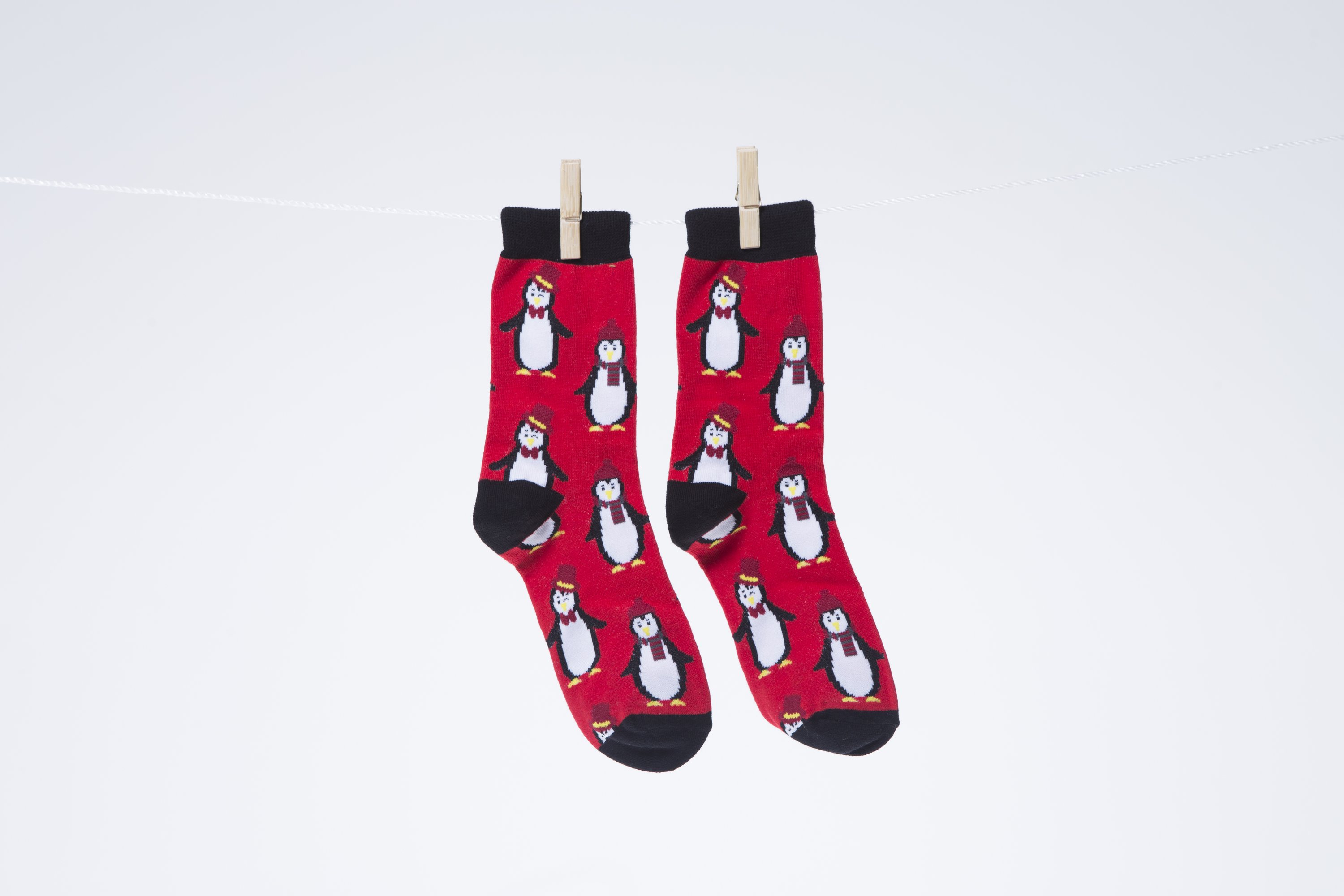 Men's Christmas socks featuring a playful penguin design, made from soft combed cotton.