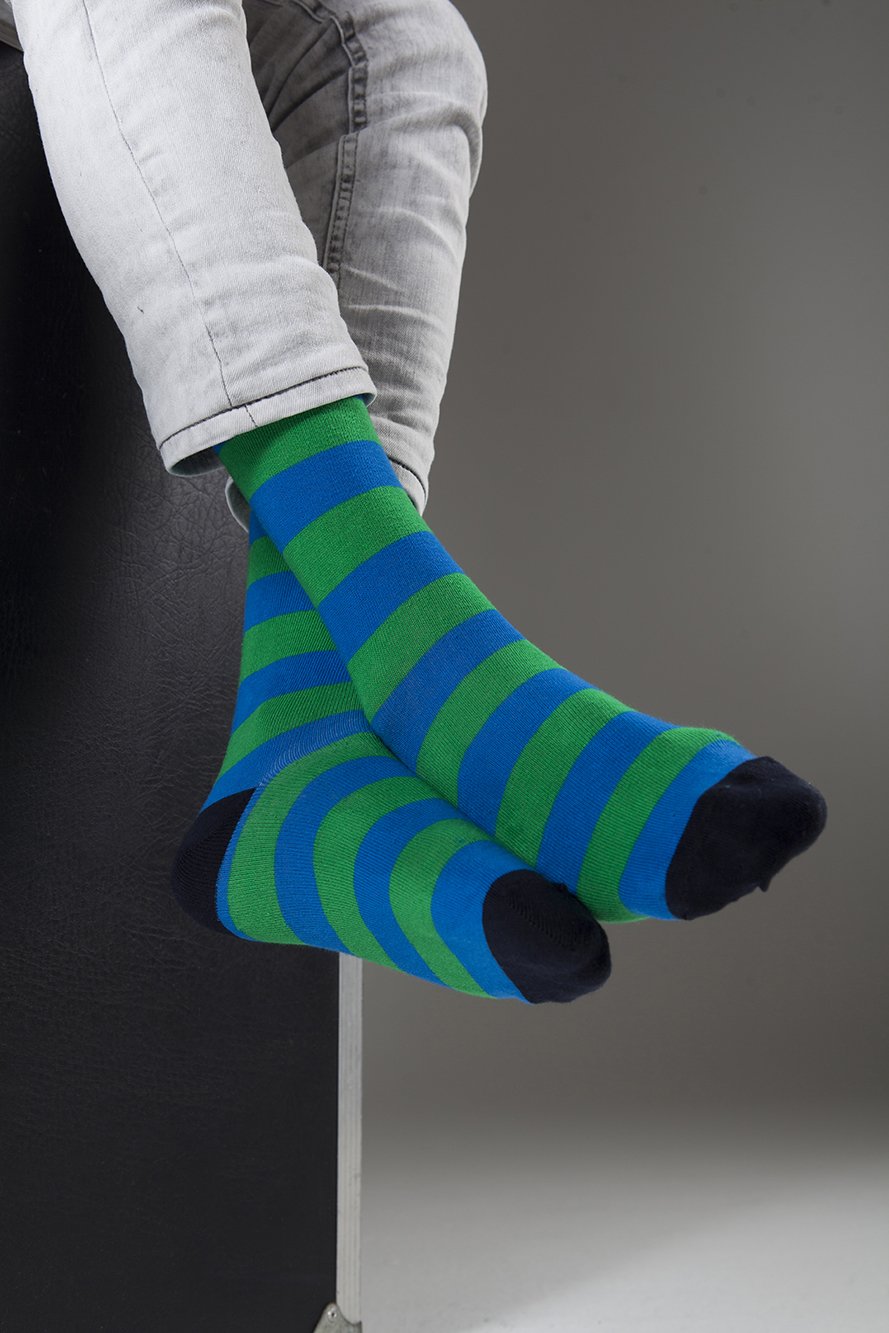 A collection of colorful men's striped socks displayed in a luxurious gift box, showcasing their trendy designs and premium quality.