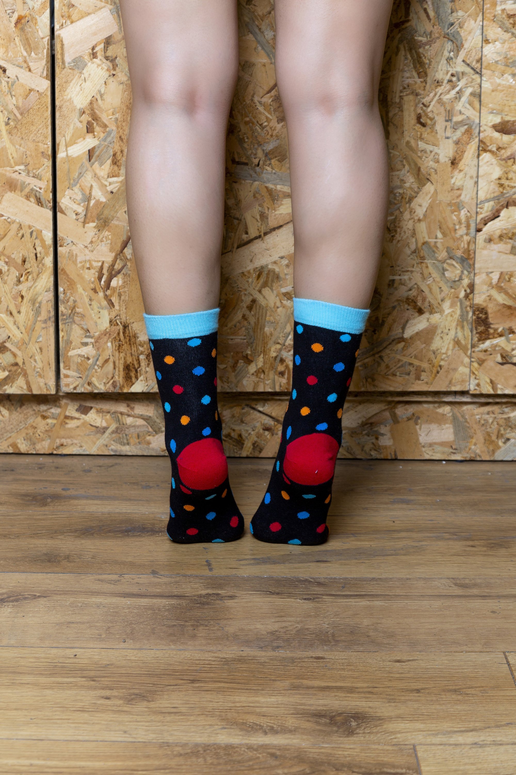 A pair of Women's Black Sky Dot Socks featuring a vibrant black and colorful dot pattern, made from soft Turkish cotton for comfort.