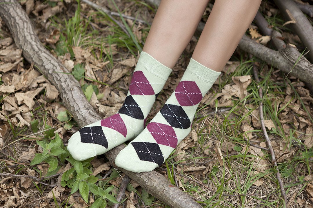 A pair of Women's Pistachio Argyle Socks featuring a vibrant green color and trendy argyle pattern, perfect for adding style to any outfit.