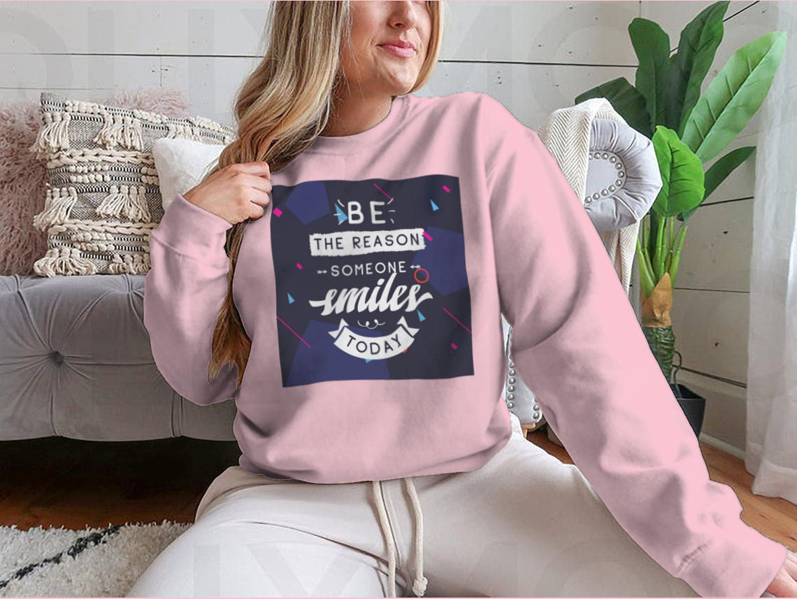 A cozy sweatshirt featuring the inspirational phrase 'Be The Reason Someone Smiles Today' in a stylish design, perfect for casual wear.