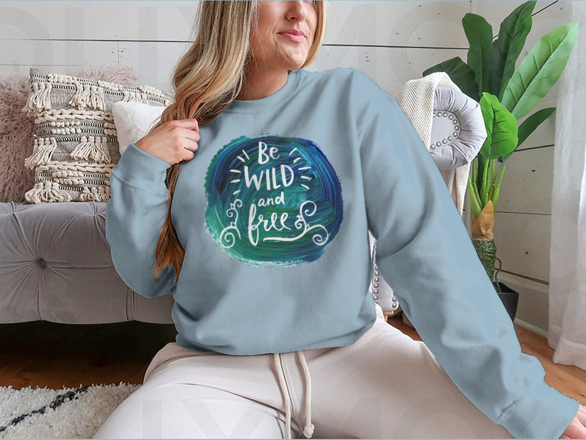 A stylish hand lettering quote 'Be Wild And Free' on a creative vector design, showcasing a blend of cotton and polyester fabric.
