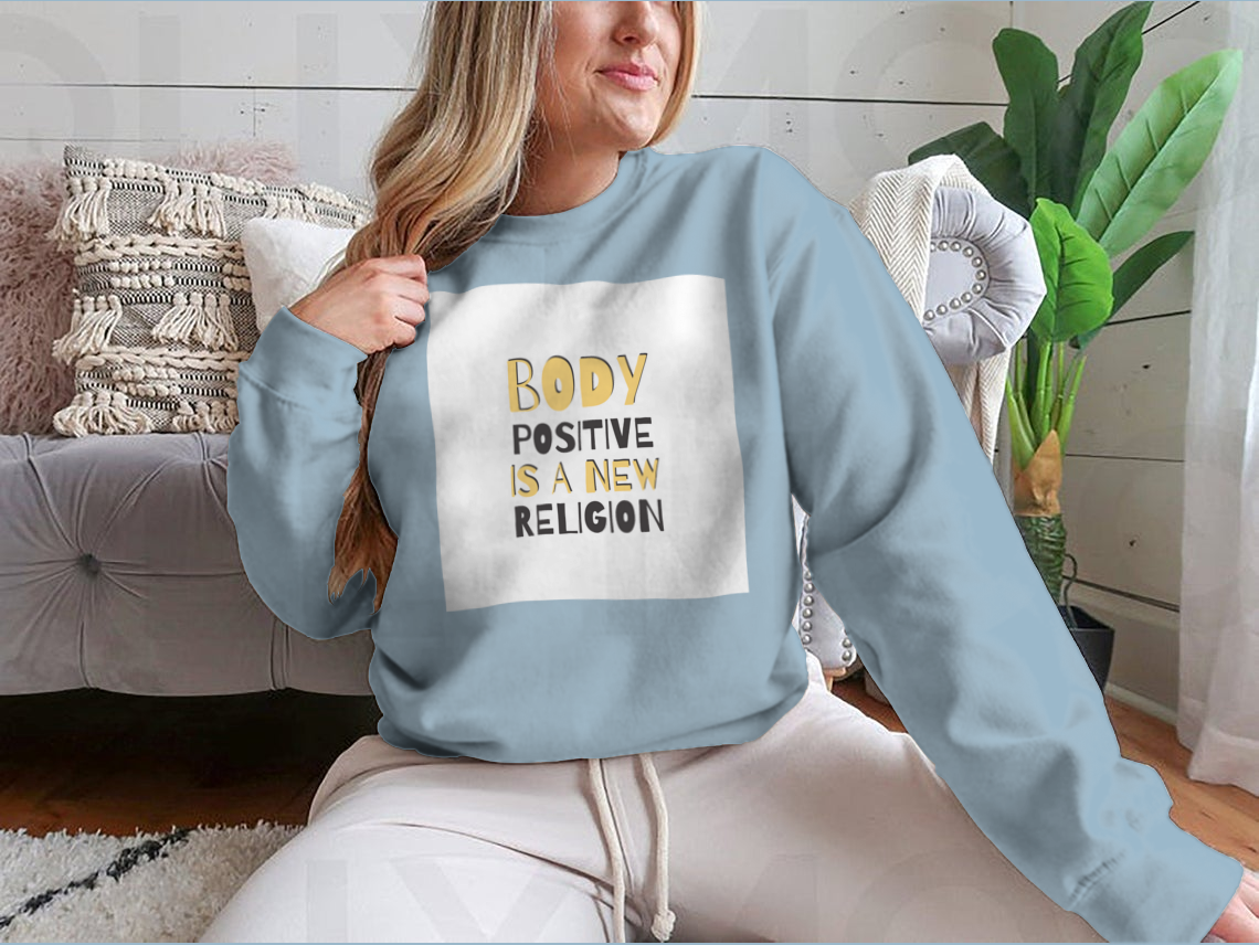 A cozy sweatshirt featuring the motivational phrase 'Body Positive Is A New Religion', showcasing a classic fit and soft fabric.