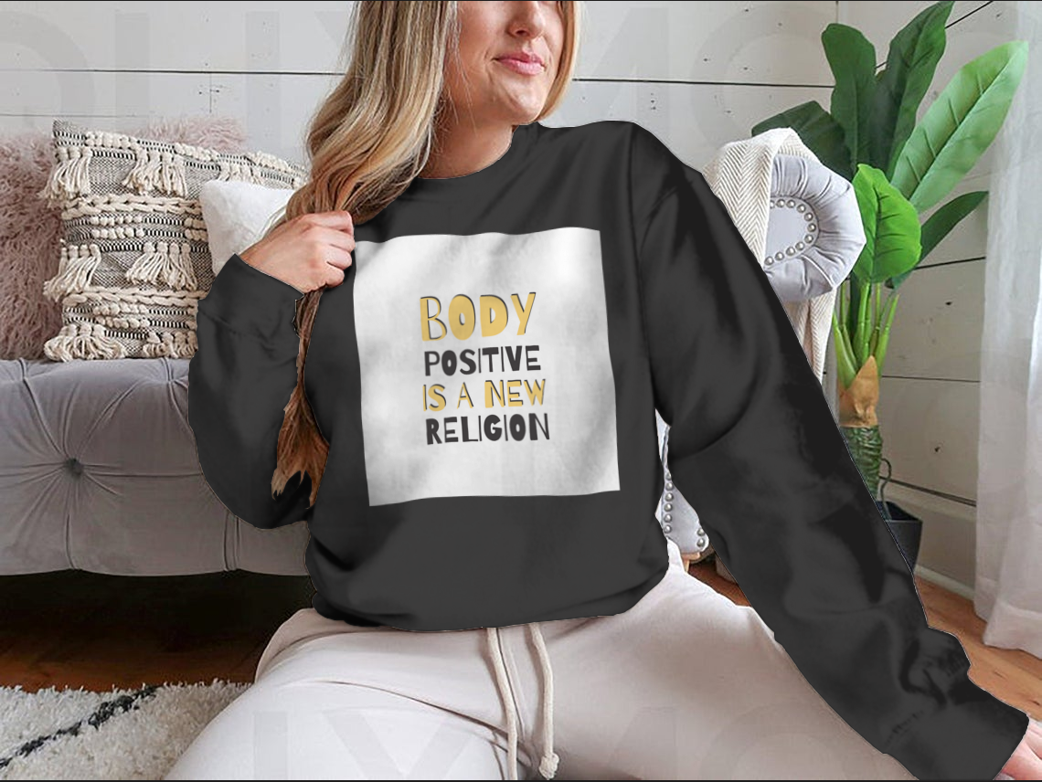 A cozy sweatshirt featuring the motivational phrase 'Body Positive Is A New Religion', showcasing a classic fit and soft fabric.