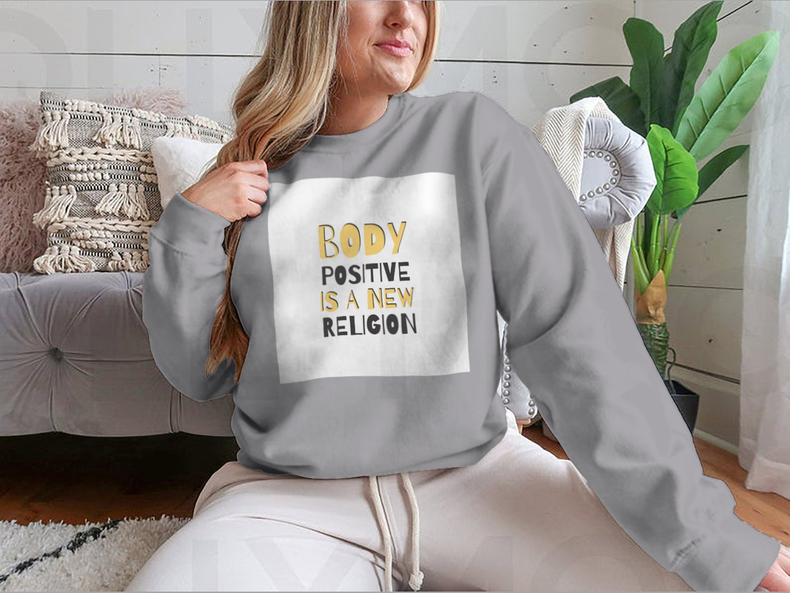 A cozy sweatshirt featuring the motivational phrase 'Body Positive Is A New Religion', showcasing a classic fit and soft fabric.