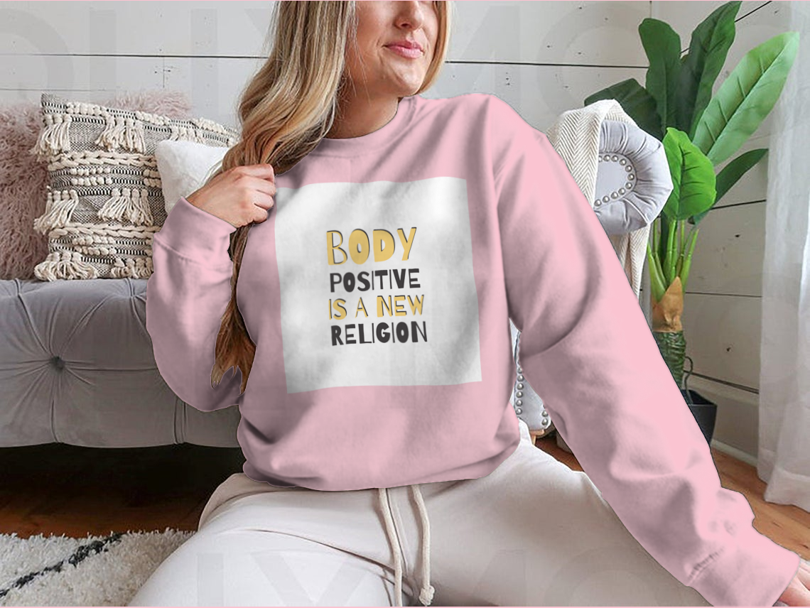 A cozy sweatshirt featuring the motivational phrase 'Body Positive Is A New Religion', showcasing a classic fit and soft fabric.