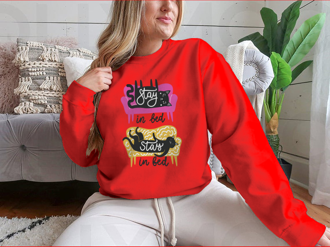 A cozy apparel featuring cats on a sofa with the text 'Stay In Bed', perfect for cat lovers.