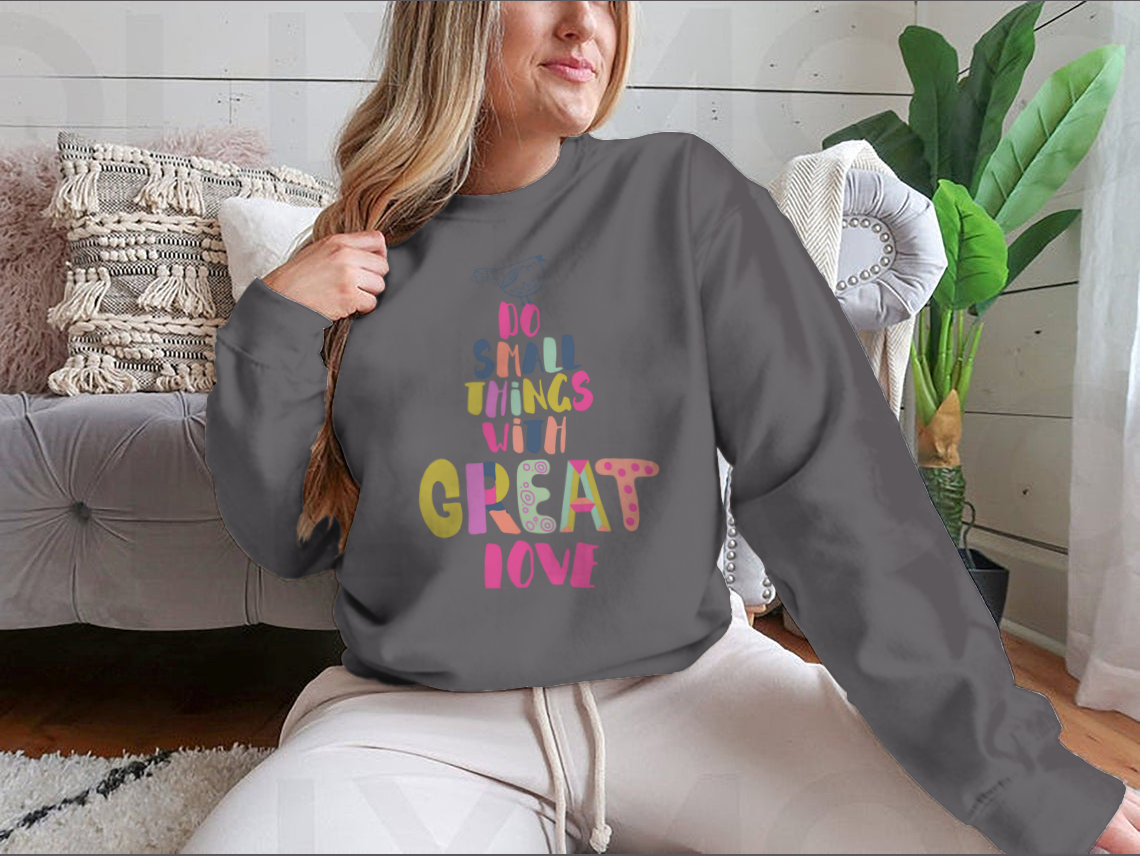 A cozy sweatshirt featuring the inspirational phrase 'Do Small Things With Great Love' in a stylish design, perfect for casual wear.