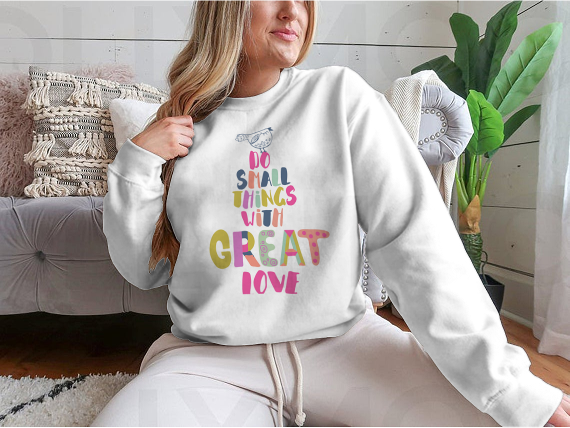 A cozy sweatshirt featuring the inspirational phrase 'Do Small Things With Great Love' in a stylish design, perfect for casual wear.