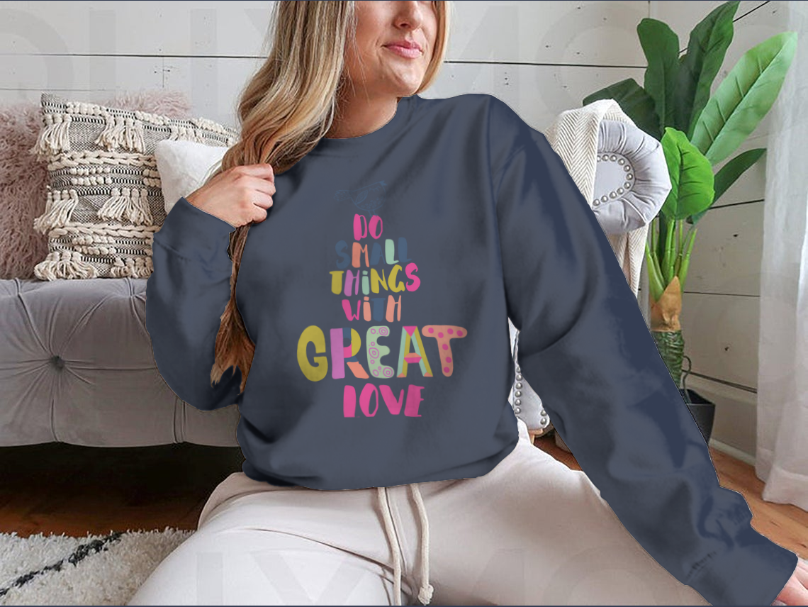 A cozy sweatshirt featuring the inspirational phrase 'Do Small Things With Great Love' in a stylish design, perfect for casual wear.