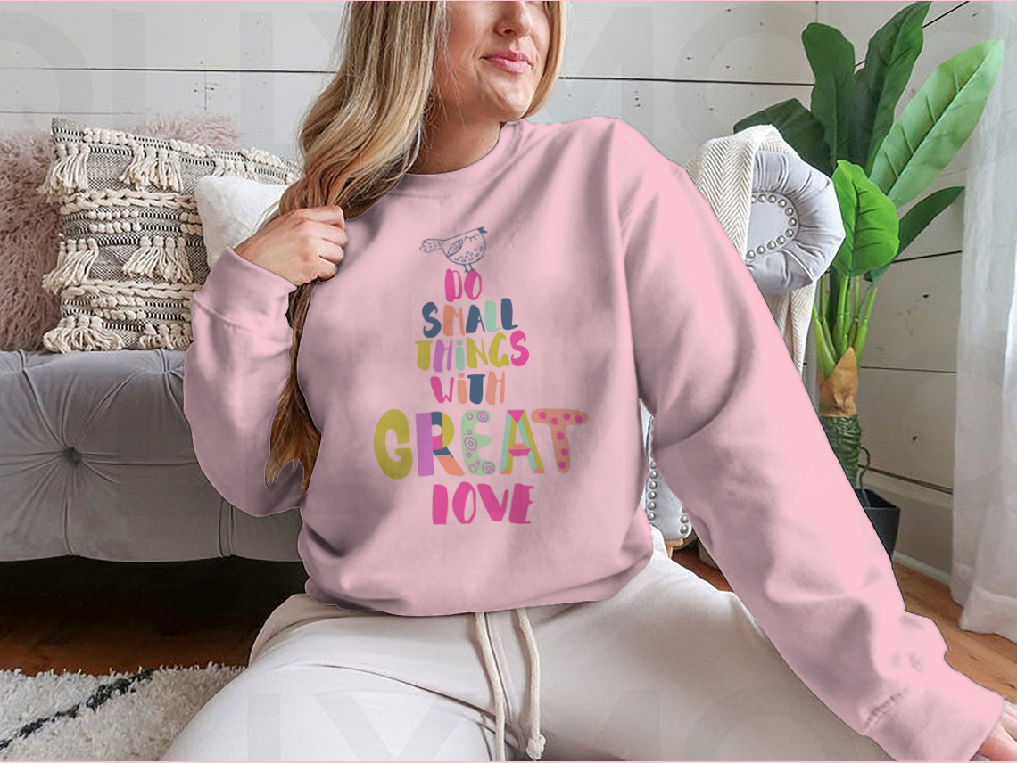 A cozy sweatshirt featuring the inspirational phrase 'Do Small Things With Great Love' in a stylish design, perfect for casual wear.