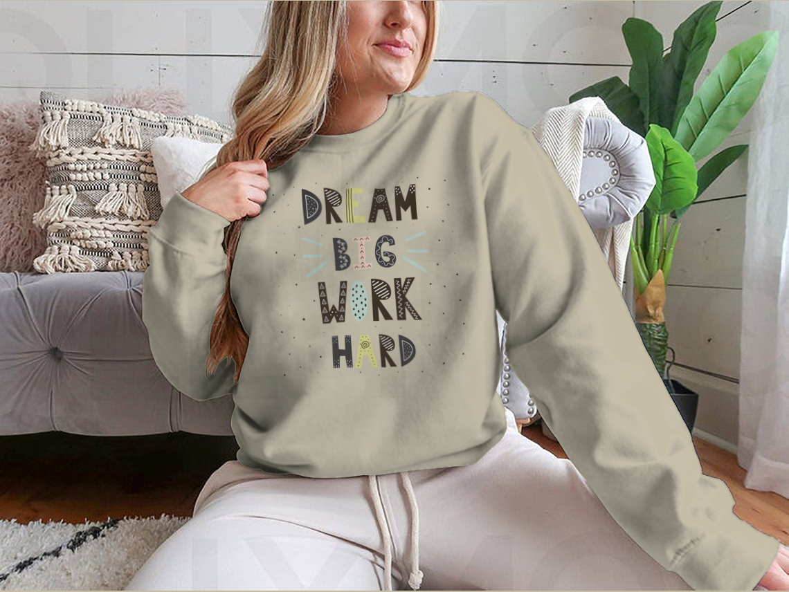 A stylish t-shirt featuring hand-drawn lettering that reads 'Dream Big Work Hard', showcasing a motivational quote in a comfortable fit.