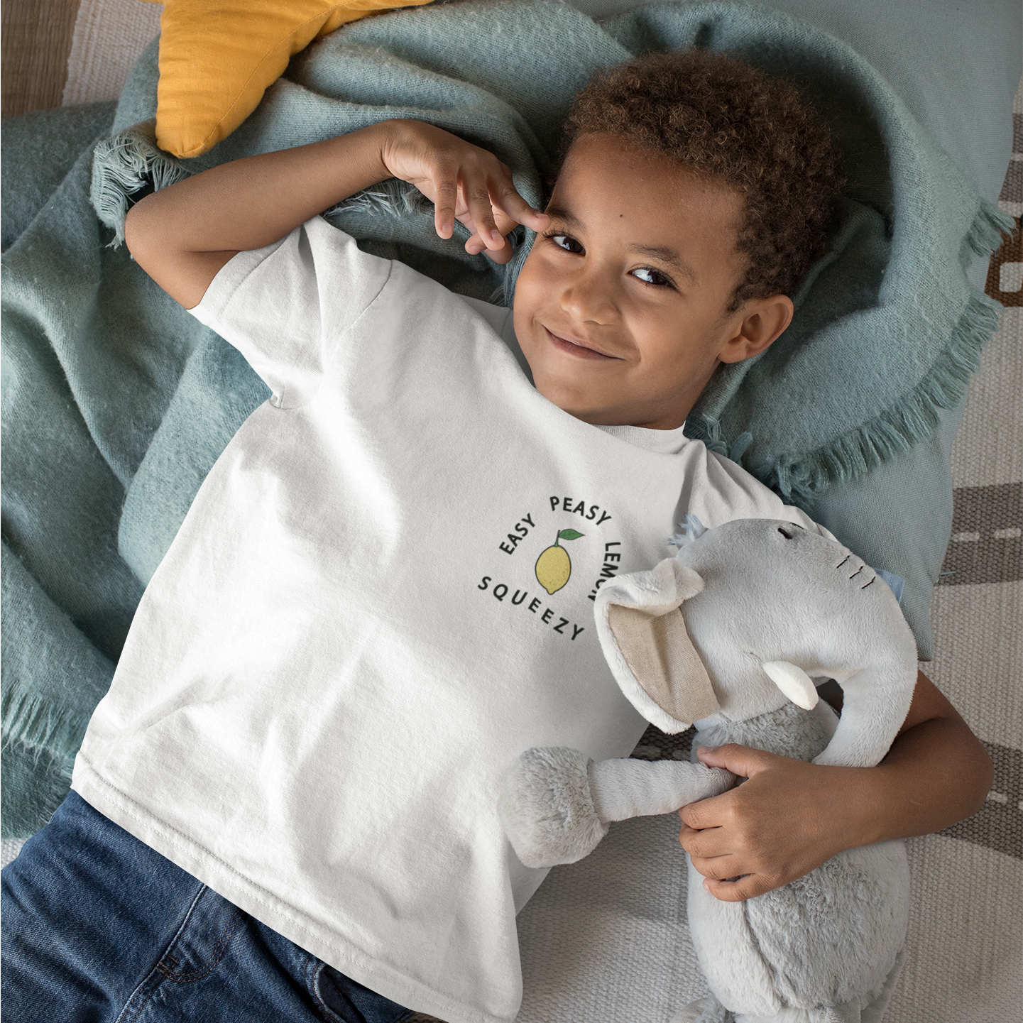 A vibrant yellow kid's t-shirt with the phrase 'Easy Peasy Lemon Squeezy' printed in playful font, made from 100% organic cotton.