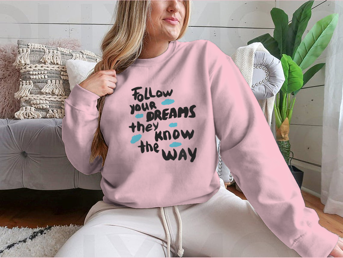 A motivational design featuring the phrase 'Follow Your Dreams They Know the Way' on a soft cotton/polyester blend fabric, showcasing a classic fit.