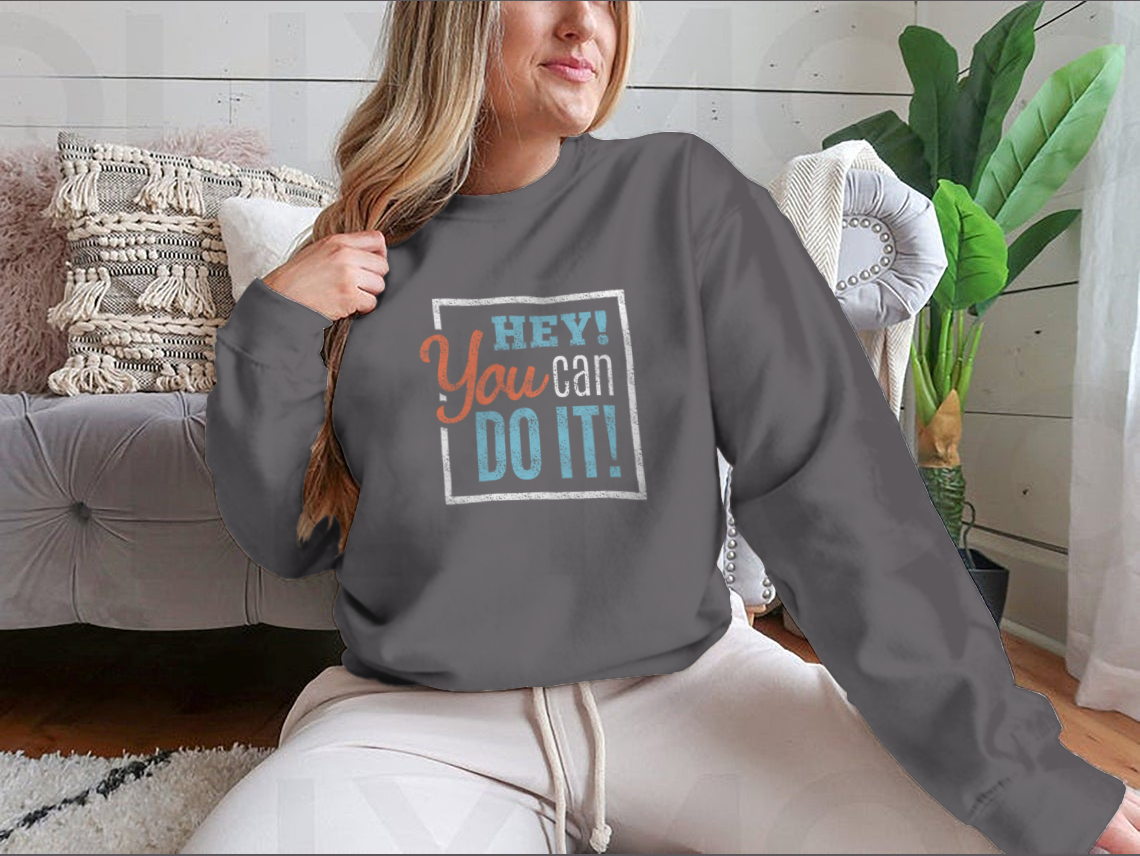 A cozy sweatshirt featuring the inspirational phrase 'Hey You Can Do It' in a stylish design, perfect for motivation and comfort.